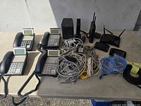 Overview of four NEC phones, network devices and cable bundles on table