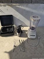 Overview of blender, hand mixer, attachments and open storage case