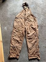 Full view of brown Carhartt cotton overalls showing overall construction, color, and condition.