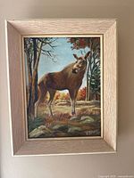 Frontal image of the framed oil painting depicting a moose in a forest landscape, signed E. Banks
