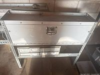 Front view of metal organizer with large drawer on top and eight smaller drawers below