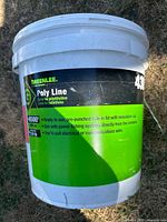 White plastic bucket labeled Greenlee Poly Line, used for storage or related purpose.