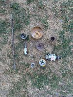 Overview of all drill bits and hole saws arranged on grass surface, showing varied sizes and attachment pieces.