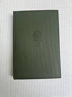 Front cover of the antique book showing green textured hardcover with embossed flower design.