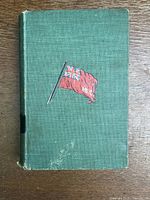 Front view of green hardcover book with red flag emblem and visible wear on cover edges and surface.