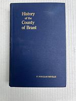 Front cover of the book showing dark blue hardcover with the gold embossed title 'History of the County of Brant' and author 'F. Douglas Reville'.