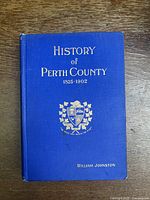 Front cover of the blue hardcover book with embossed gold title and crest