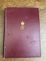 Front cover of the biography book with gold embossed crown and monogram 'ER' on a burgundy hardcover.