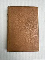 Front cover of a leather-bound book with textured light brown leather and a single gold border line.