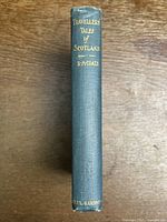 Spine of the book showing gold lettering 'Travellers' Tales of Scotland R.H. Coats' on green cloth cover.