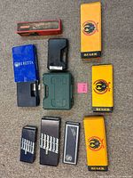 Group shot of eleven assorted firearm boxes and cases