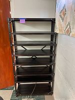 Full view of black metal shelving unit showing all eight shelves and cross-brace