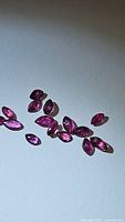 Top-down photo of loose marquis cut rubies showing their shape, size variation, and clarity under lighting.
