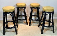 four black bamboo-style bar stools with mustard seats