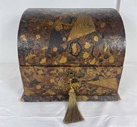 Front angled view of domed leather-bound Chinese stationery box, exterior decoration visible, key with tassel in lock