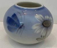 Front view showing butterfly and daisy motif on round porcelain vase