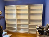Front view of three white bookcases aligned side by side