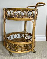 Full view of two-tier bamboo wicker trolley with handle and casters