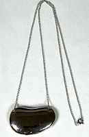 Full view of closed bean locket pendant on chain