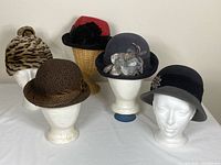 Group shot of the five vintage hats on stands