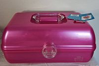 Front view of the pink Caboodles On The Go Girl case showing the clear handle and latch, with attached tag.