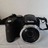 Front view of Kodak Pixpro AZ252 camera showing lens and front body with textured grip and brand markings.