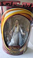 Full view of the Galadriel figure in its original sealed plastic blister packaging, including branding and background artwork.