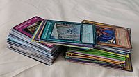 Two stacks of assorted Yu-Gi-Oh cards showing a variety of card backs and fronts.