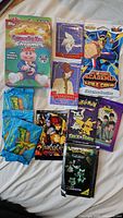 Nine assorted sealed trading card packs from multiple franchises arranged on a surface: Garbage Pail Kids Chrome box and some individual packs, Anastasia, My Hero Academia, Thundercats, Pokémon Trick or Trade, Pokémon Black Edition, The Beatles.