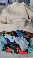 Pile of assorted vintage clothing with various colors and patterns