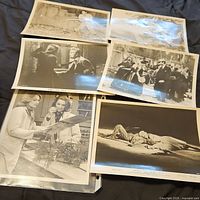 Photo showing seven vintage black and white lobby movie cards arranged on a black surface