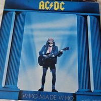 AC/DC Who Made Who album cover with boy in school uniform playing guitar between columns