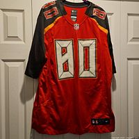 Front view of Nike On Field Tampa Bay Buccaneers Howard jersey, number 80 printed on front, hanging on door