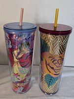Pair of Starbucks tumblers showing overall view and design patterns, lids, and straws