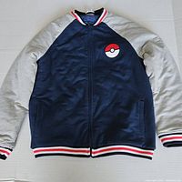 Front view of the navy and grey Pokemon kids jacket laid flat showing full jacket and embroidery detail