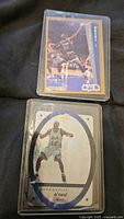 Two Shaquille O'Neal basketball cards, one rookie card from Fleer 1992-93 and one insert card with holographic oval design, both sleeved.