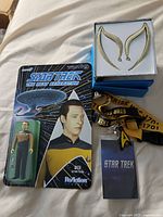 Photo showing Data action figure in original 'Star Trek The Next Generation' packaging, Klingon forehead ridges in a box, Star Trek lanyards, and Star Trek card/booklet.