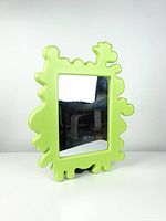 Front view of the green Barnslig foam mirror showing unique irregular shaped frame and rectangular mirror surface.