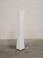 Front view of the tall floor lamp showing its white paper shade and rectangular shape with metal legs.