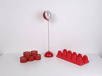 Photo showing the entire lot: red Space Age ball desk clock on tall stand, red record/document stand with eight slots, and six small red mesh baskets organized in two rows.