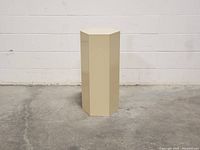 Front view of the vintage laminated hexagon pedestal showing its full height and hexagonal shape.