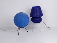 Wide view of both lamps showing the blue orb jelly globe on a tripod stand and the dark purple jelly mushroom lamp with shade placed side by side.