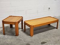 Full view of both solid oak tables, coffee table long rectangular and side table smaller square, showing natural wood grain and design.