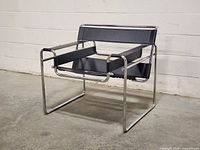 Front three-quarter view showing black leather straps and chrome frame