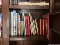 Bookshelf middle shelf with assorted books including titles in various colors and sizes