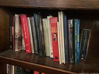 Wooden bookshelf filled with various books related to history, culture and literature