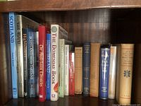 Books arranged on a wooden bookshelf, titles visible include topics on Scotland, Highlanders, the Domesday Book, and historical records.