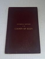 Front cover of maroon hardcover book with gold title 'Historical Sketches of the County of Elgin'.