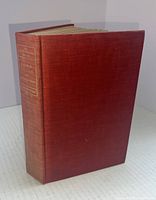 Front and side view of a red hardcover book with gilt lettering on spine.