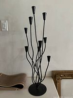 Full view of black metal candelabra showing eight holders and round base